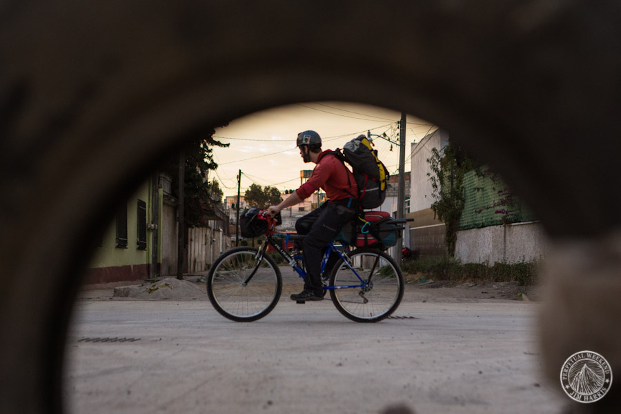 Todd Tumolo pedals past a discarded tire in Cholula