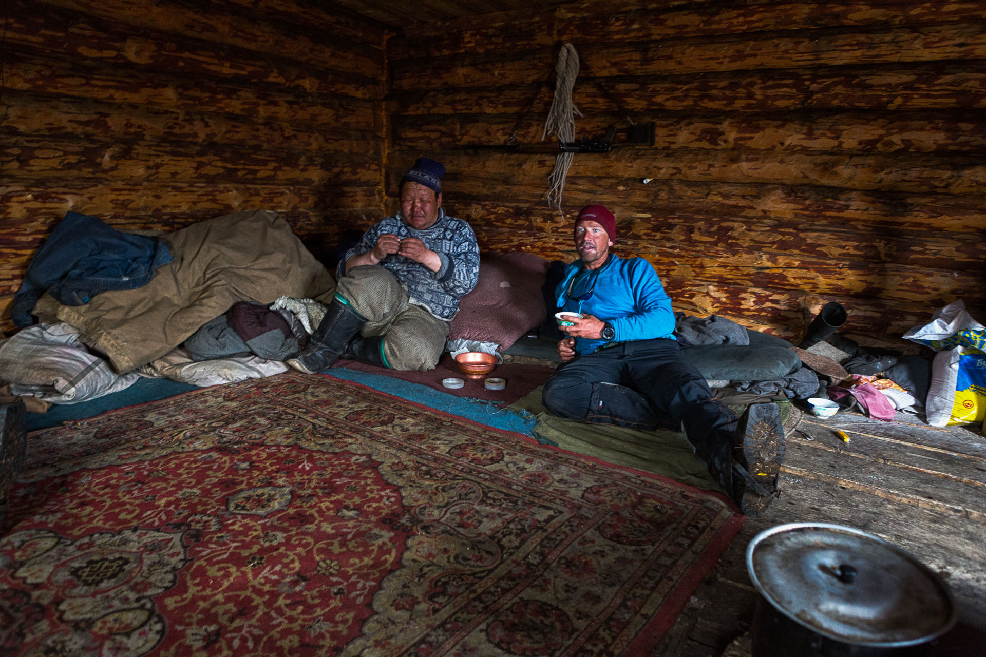 A Mongolian herder rolls a cigarette in newsprint while Forrest McCarthy sips a salty-milk Suutei Tsai tea.